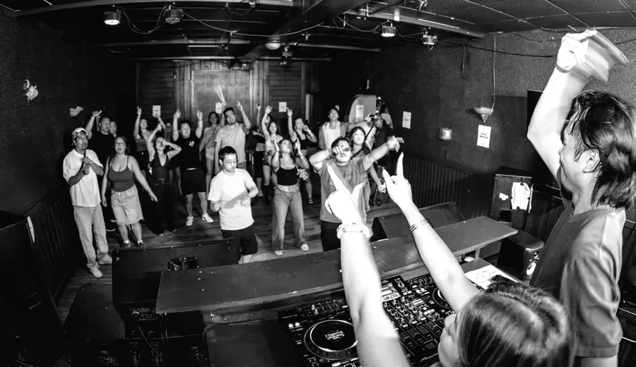 Crowd with hands up in front of the booth